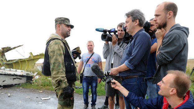 Journalists with Ukrainian rebel officer at site of MH17 disaster - file pic