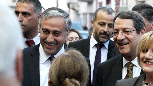 Cypriot President Nicos Anastasiades (R) and Turkish Cypriot leader Mustafa Akinci (L) chat with members of the public in Limassol on 8 June 2015
