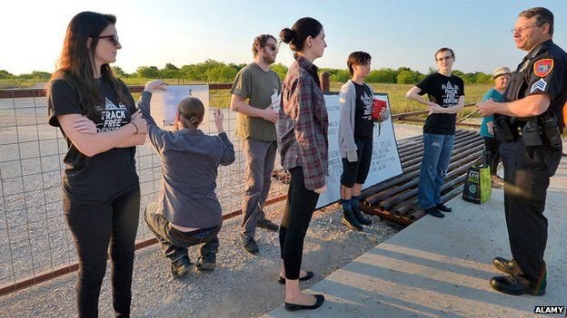 Denton Police Sgt. Scott Jenkins, right, issues a warning to the fracking protesters on June 2, 2015 in Denton, Texas