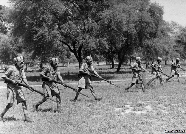 circa 1940: Indian infantrymen wearing gas masks over their turbans during exercises in preparation for duty in the Second World War.