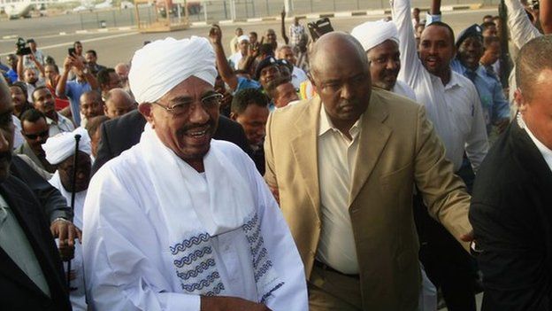 Hundreds of supporters welcome Sudanese President Omar al-Bashir, centre left, on his arrival from South Africa as he walks through the crowd at the airport in Khartoum