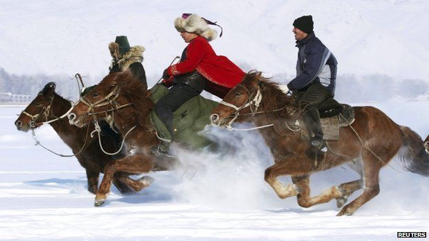 Herdsmen take part in a horse race during a local snow festival in Altay, Xinjiang region, 12 February 2014
