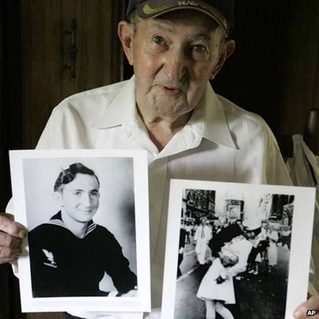 Glenn McDuffie holds a portrait of himself as a young man, left, and a copy of Alfred Eisenstaedt's iconic Life magazine shot of a sailor (31 July 2007)