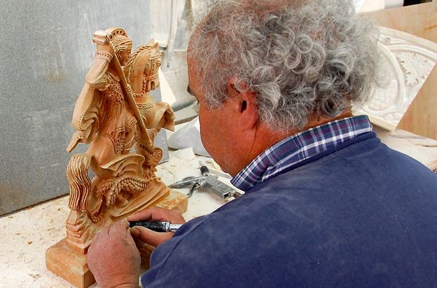El Sr. Anastas está esculpiendo una pequeña estatua de San Jorge matando a un dragón