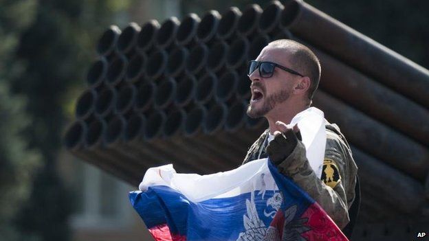 A pro-Russian rebel displays a flag in central Donetsk, 24 Aug