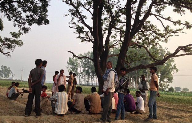 Жители деревни собираются возле дерева, где были найдены девушки в Бадауне
