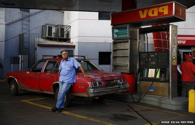 Ένας άντρας γεμίζει το 1976 του Chevy Nova με βενζίνη σε ένα βενζινάδικο PDVSA στο Καράκας της Βενεζουέλας