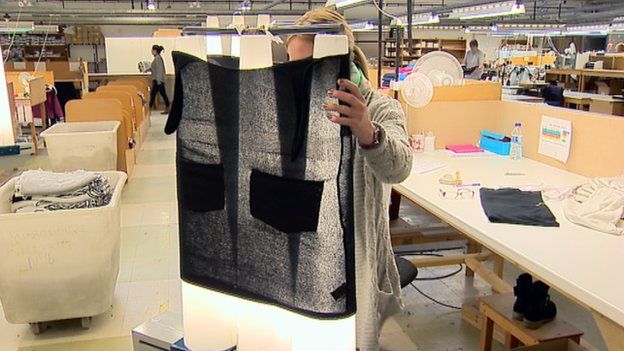 Woman inspects woollen garment