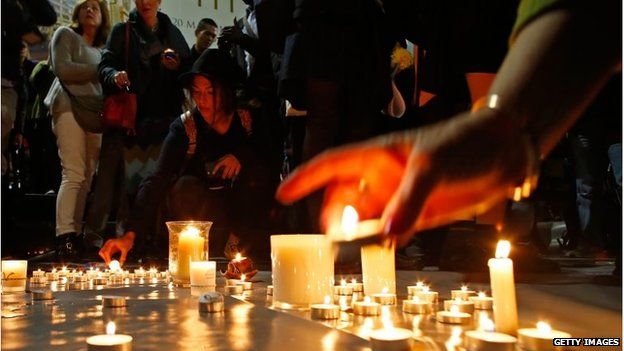 A woman lights a candle for the prisoners to be executed in Indonesia, during a vigil in Sydney