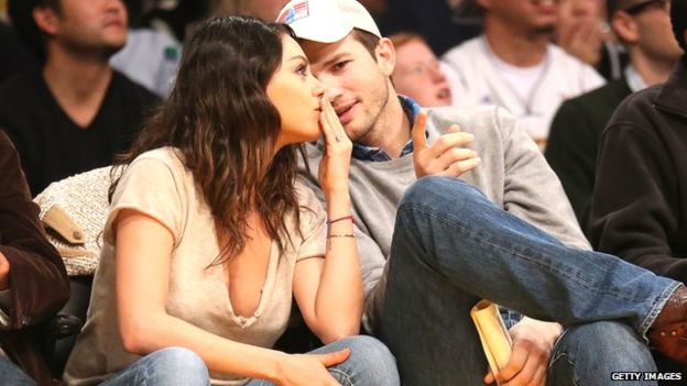 Ashton Kutcher has a private chat with his wife at a sports game