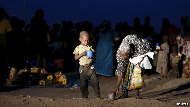 A child and mother rescued from Boko Haram in Sambisa forest by Nigeria Military pick up their food after arriving at the internally displaced people's camp in Yola, Adamawa State, Nigeria, 2 May 2015