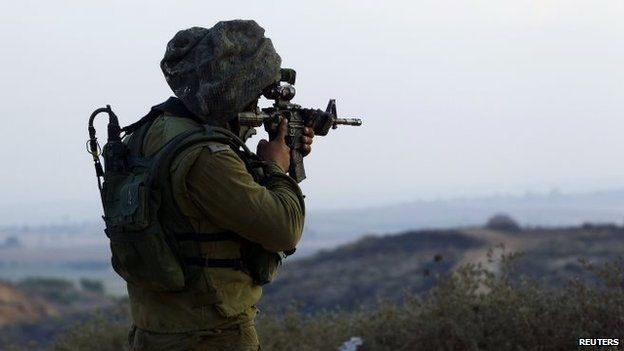 An Israeli soldier looks through his rifle at the northern Gaza Strip (21 July 2014)