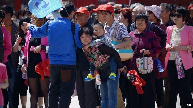 Семья (С) присматривает после посещения Запретного города в Пекине 3 мая 2015 года.