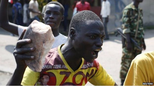 A protester gestures with a stone during a protest against President Pierre Nkurunziza's decision to run for a third term in Bujumbura on 29 May 2015