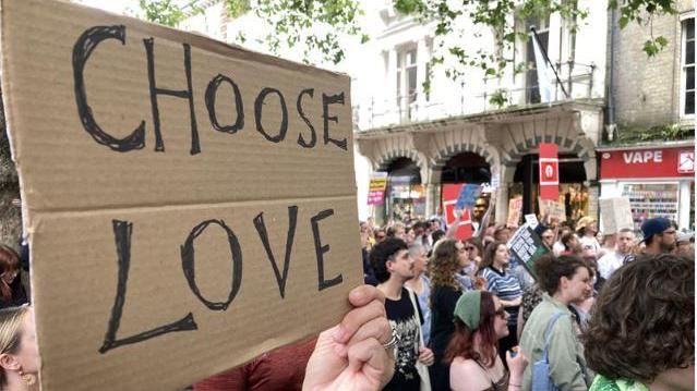 'Choose Love' placard held up by protester