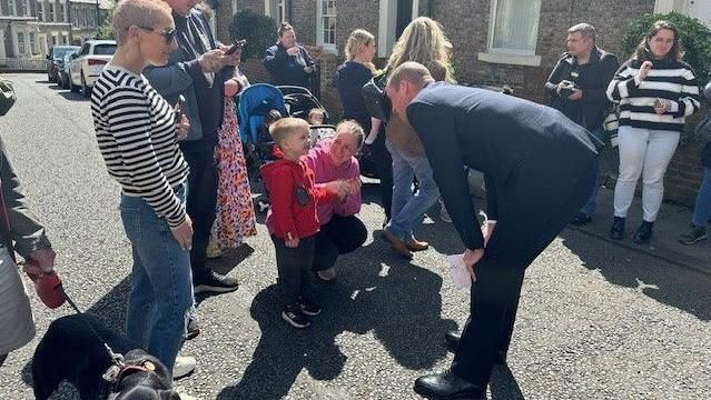 Prince William speaking to a child outside