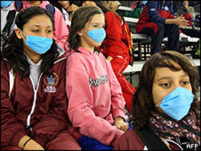 Mexicanos vistiendo máscaras para evitar brote de gripe porcina.