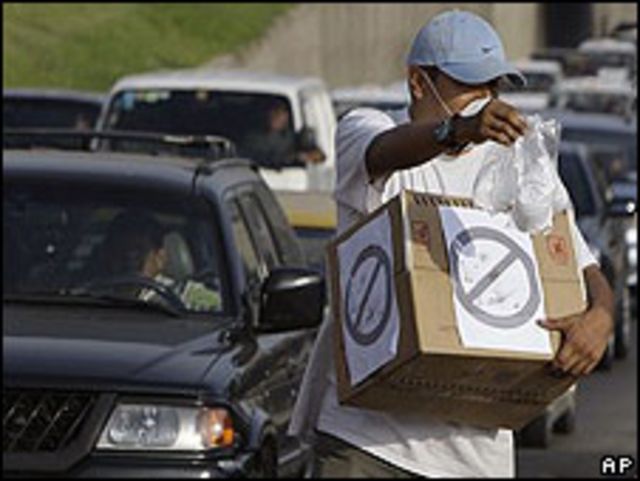 Un hombre vende mascarillas contra la gripe porcina en una autopista de Lima