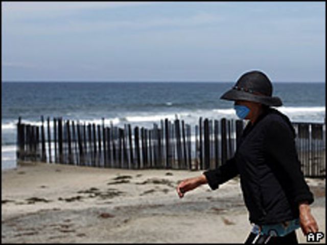 Una mujer camina cerca de la frontera entre EE.UU. y México