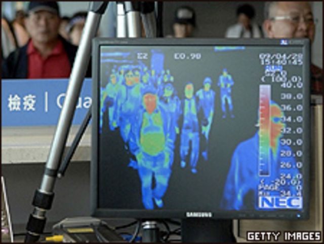Funcionarios del aeropuerto Incheon ven un monitor donde se refleja las imágenes de un escáner térmico