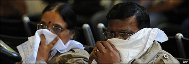 Turistas indios se cubren la boca con pañuelos