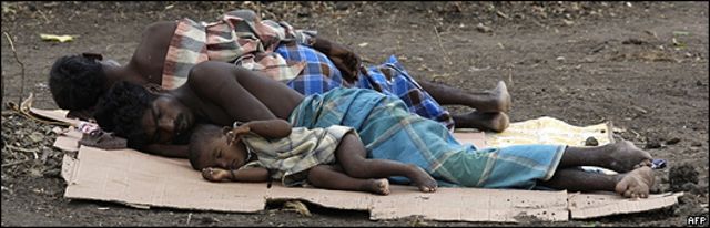 Refugiados tamiles descansan sobre cartones