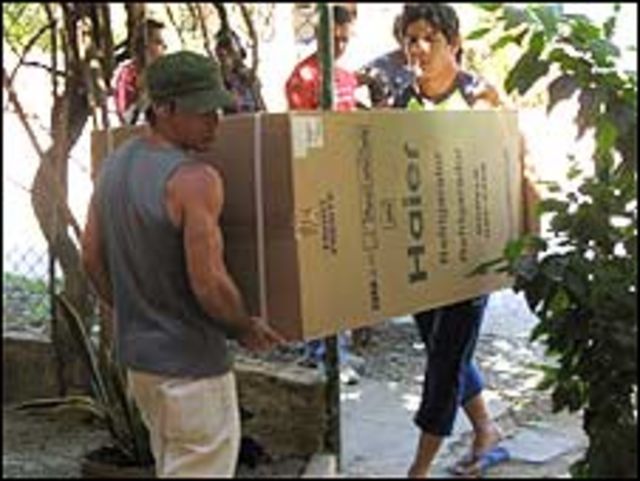 Personas cargando un refigerador / Foto: Raquel Pérez
