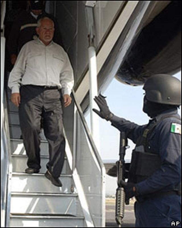 Uno de los funcionarios detenidos en el estado de Michoacán baja de avión de la policía