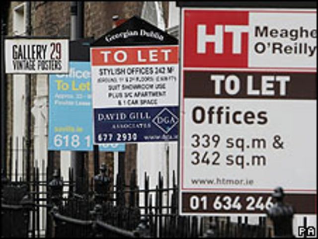 Carteles de agencias inmobiliarias ofertando propiedades para alquiler o la venta.