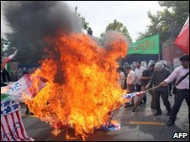 Estudiantes iraníes queman banderas británicas y de EE.UU., durante una protesta fuera de la embajada británica en Teherán el 23 de junio de 2009