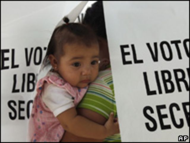 Una votante con una niña, en centro electoral en Hermosillo