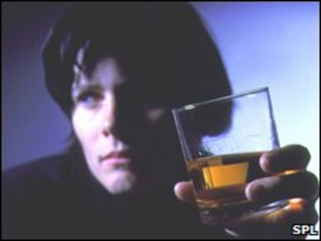 Mujer con vaso de whiskey.