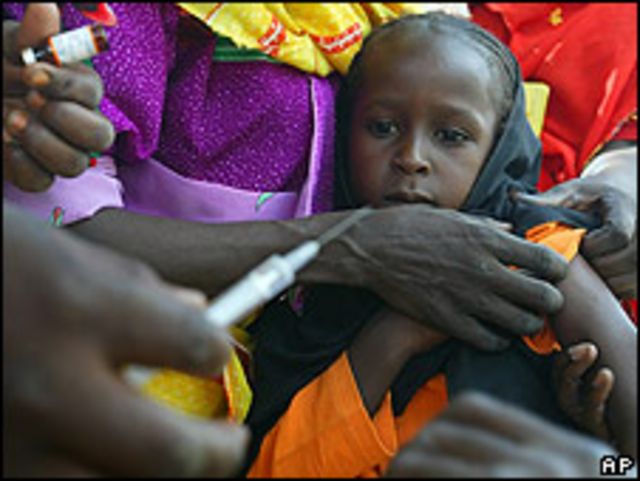 Niña sudanesa es vacunada por voluntarios de UNICEF