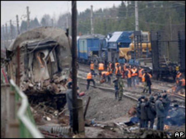 Investigadores y trabajadores de rescate se ven en medio de los restos del tren