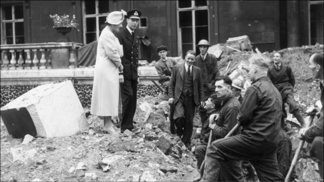 Король Георг VI с королевой Елизаветой совершают обход территории Букингемского дворца после немецкой бомбежки 13 сентября 1940 года.

