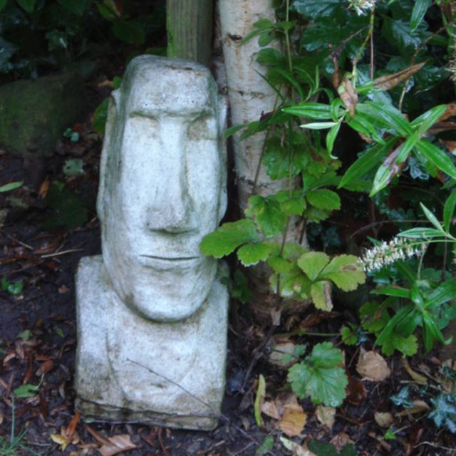 un moái decora un jardín