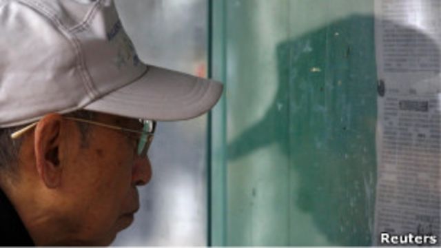 北京市民在街頭報欄看報紙(23/03/2011)