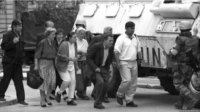 Warga Sarajevo melewati panser pasukan PBB di Sarajevo yang dikepung rapat oleh pasukan Serbia.