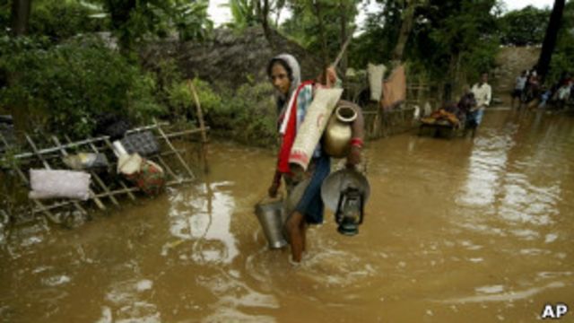 Женщина идёт по затопленной дороге