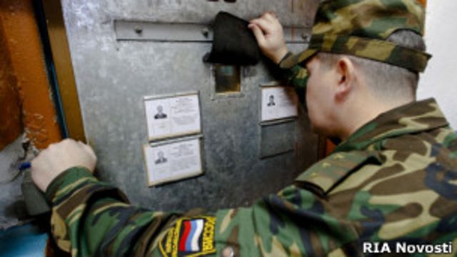 Надзиратель заглядывает в "глазок" тюремной камеры