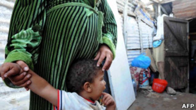 Mujer embarazada junto a uno de sus hijos