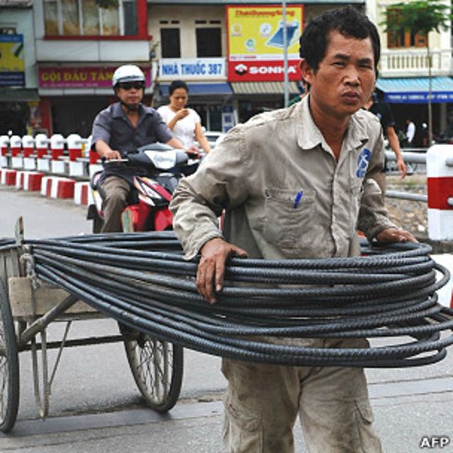 Một công nhân chở vật liệu tới công trường ở Hà Nội hôm 27/6