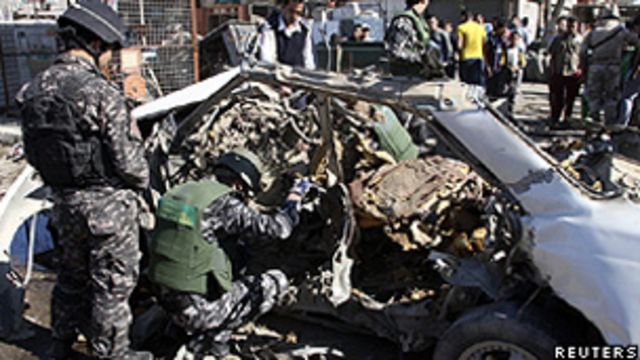 Policiais iraquianos examinam os restos de um carro-bomba no bairro Cidade Sadr, em Bagdá (Reuters)