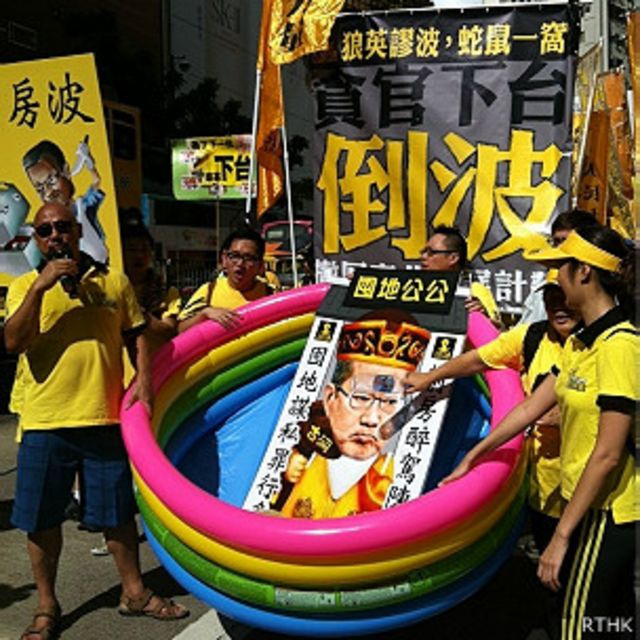 香港民主派政團人民力量示威者推著諷刺陳茂波的道具遊行（香港電台圖片28/7/2013）