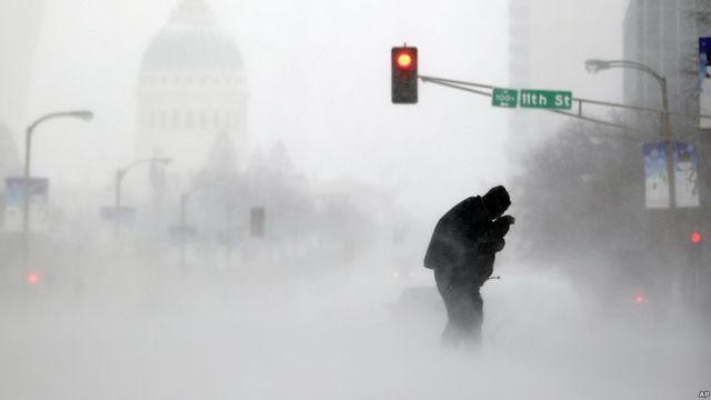 Una persona intenta cruzar la calle en una tormenta de nieve en San Luis, Misuri, EE.UU.