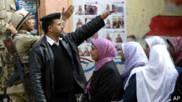 埃及公投投票站外的保安人员与民众