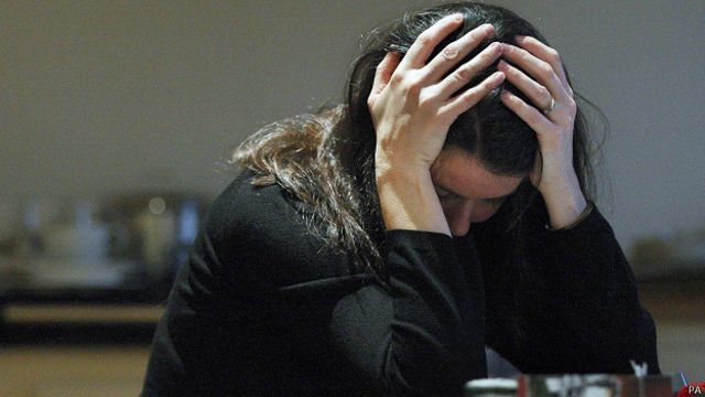 Mujer sentado agarrándose la cabeza