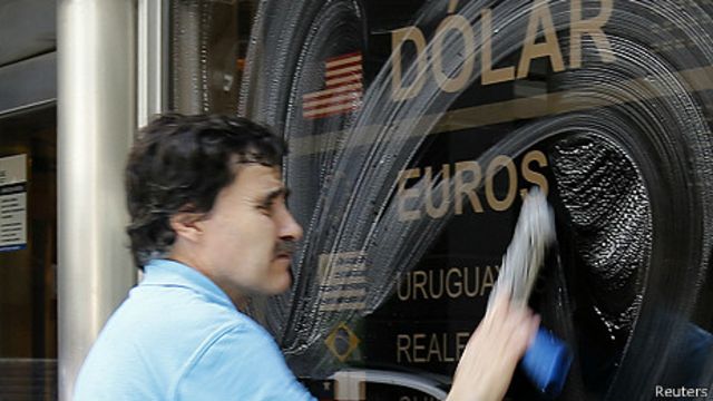 hombre limpia un ventanal en una casa de cambio en buenos aires