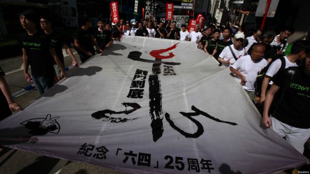 遊行者舉著象徵著1989年六四天安門學生運動的標誌，以示紀念。