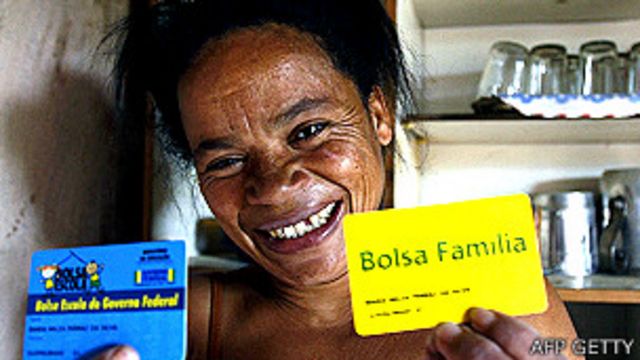 Mujer mostrando una tarjeta del programa Bolsa Familia